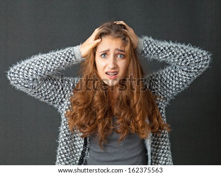 Teenage Girl with beautiful long curly hair. She looks frustrated and annoyed.