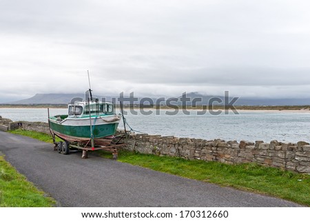 a Fisher boat on a trailer, parked on a road in Ireland