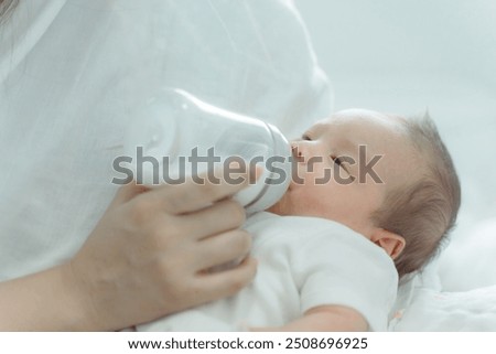 Similar – Image, Stock Photo Newborn drinking milk from a baby bottle, sitting on mom legs outdoors