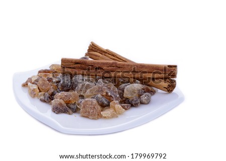 Rock candy sugar and cinnamon on a porcelain saucer