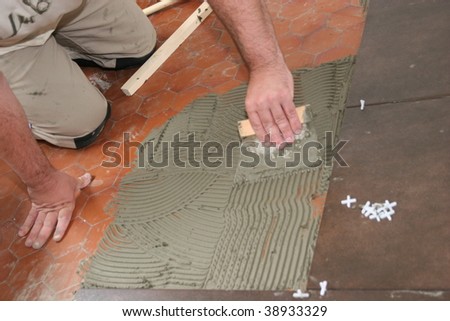 man installs ceramic tiles on the floor