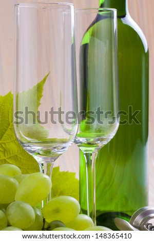 White wine bottle presented with wine glass on a orange background