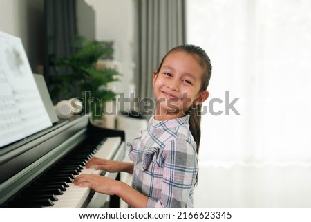 Similar – Image, Stock Photo Smiling child playing piano in cozy room in daylight