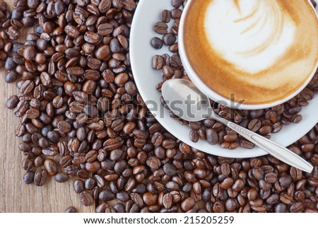 Coffee cup and beans on wood back ground (Coffee beans focus)