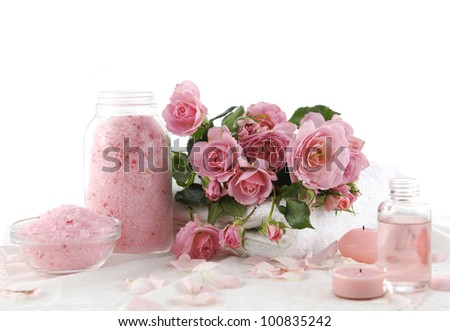 Spa setting with towel and branch roses on towel and soap, salt in bowl, massage oil