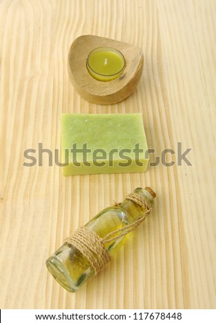 Candle in bowl , handmade soaps , massage oil on wooden board