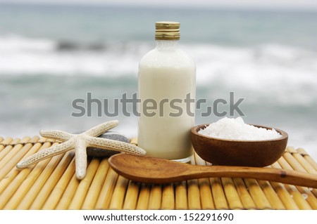 salt in wooden bowl ,spoon ,massage oil starfish on wooden mat -beach in sunset time