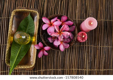Many red frangipani in bowl ,red candle ,leaf on bamboo mat