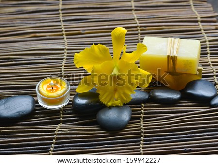 Zen rock and Handmade soap with candle, yellow orchid on bamboo mat