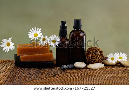 Spa setting with white flower ,soap and stones candle, massage oil,