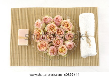 spa soap and towel with bouquet of rose on stick straw mat