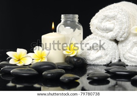 Spa Still life with frangipani flowers, candles and towels on pebbles