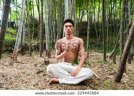 Healthy muscular young man do yoga at nature forest