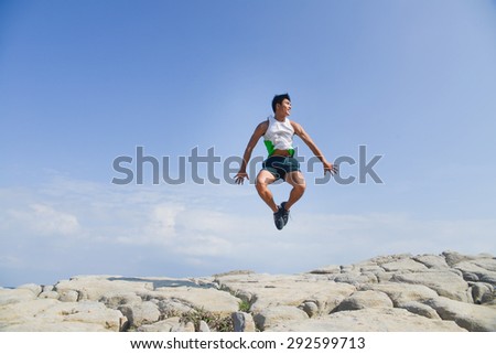 male model with muscles in exercise jumping outdoors