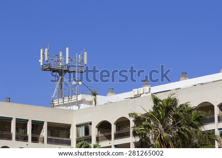 Mobile antenna in a building, against blue sky