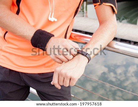 Young handsome athletic runner using his exercise gear