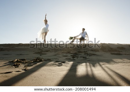 Silhouette of young beautiful couple enjoying an afternoon on beach sand dune