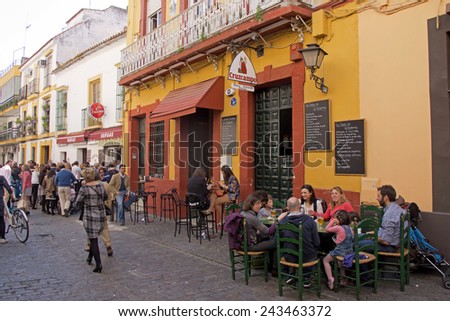 SEVILLE, SPAIN - 16 MARCH 2014: People relaxing and drinking on a terrace after the procession of Maria Auxiliadora in the district La Triana, Seville,  Spain.