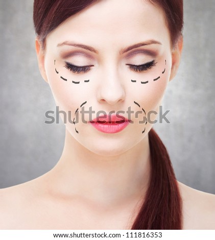 Beautiful young woman with perforation lines on her face before plastic surgery.