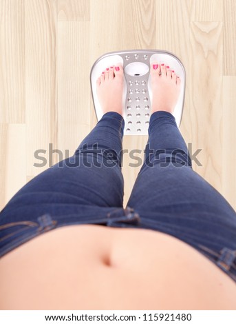 Woman on a bathroom scale - diet and overweight concept