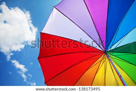 Rainbow umbrella on sky background