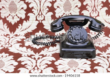 Vintage rotary phone on a retro swirly background
