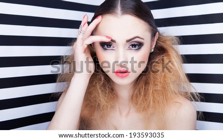 portrait of beautiful young woman with professional party make up false eyelashes on stripy background