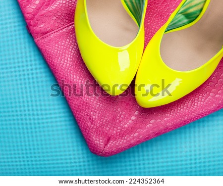 Neon high heels and snakeskin print bag, woman fashion concept