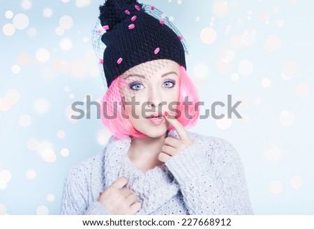 Portrait of young attractive surprised woman with pink hair wearing fancy winter hat. Christmas concept.