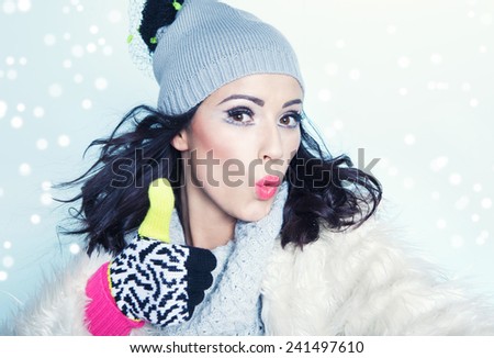 Happy woman wearing winter gloves covered with snowflakes.