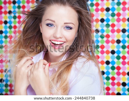 Attractive young laughing woman on spotted background, beauty and fashion concept