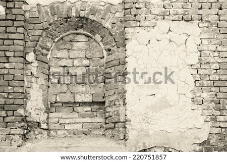 arch niche and the destroyed plaster on an old brick wall of the ancient building in monochrome tones