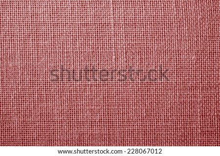 the textured background of synthetic fabric with crisscross fibers of light red color