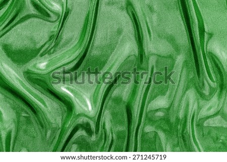 abstract background fabric with the crumpled wavy texture of green glossy color for empty and pure backgrounds