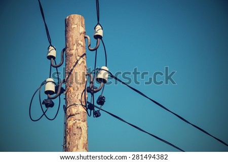 industrial a retro scenery from an old wooden column with electric wires and a cable on ceramic insulators of natural retro color closeup