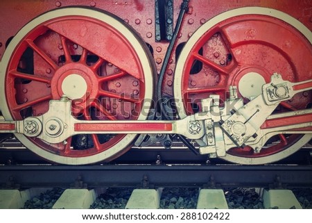 big wheels a closeup of the vintage locomotive with the steam engine on railway tracks  of red color