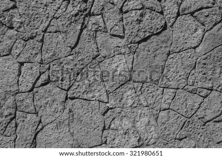 abstract texture of black color of a stone wall with cracks for empty and pure backgrounds and for wallpaper