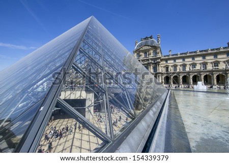PARIS - AUGUST 11: Louvre pyramid during the Summer Exhibition on August 11,2013 in Paris.Louvre is the biggest Museum in Paris displayed over 60,000 square meters of exhibition space.