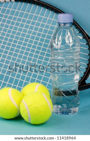 Tennis balls, racket, bottle and towel on blue background
