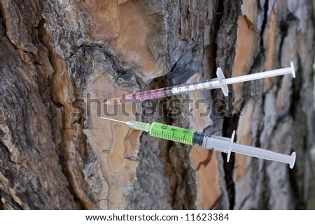 a couple of syringes fitted into a tree, pointing out the concept of drug addiction