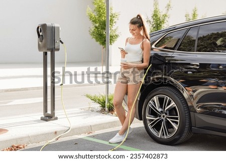 Similar – Image, Stock Photo An elegant woman charging an electric car in urban settings