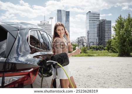 Similar – Image, Stock Photo An elegant woman charging an electric car in urban settings