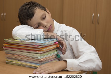 Young student sleeps on stack of books