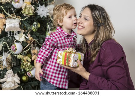 Son kisses his mother  giving Christmas gift