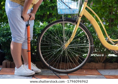 Similar – Image, Stock Photo Woman inflating bicycle tire in workshop