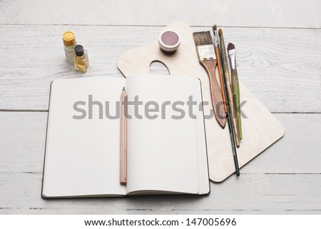 creative group of objects for painting, writing and sketching on a white hardwood table. Studio shot.