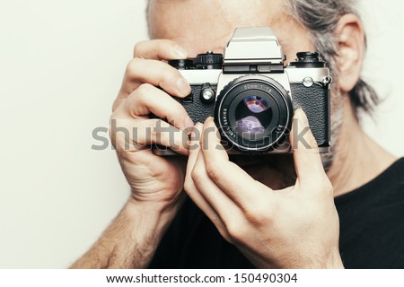 Photographer. Close up portrait of man holding vintage camera.