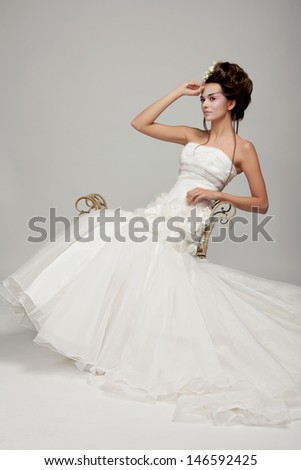 young beautiful bride sitting on a bench\
studio shooting