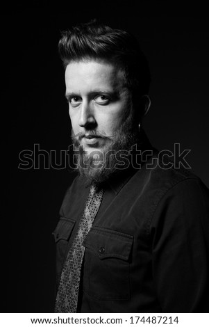 An image of a handsome man with a beard and stylish hairstyle