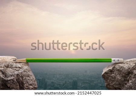 Green pencil on rock mountain over aerial view of cityscape at sunset, vintage style, Business success and strategy planning concept 商業照片 © 